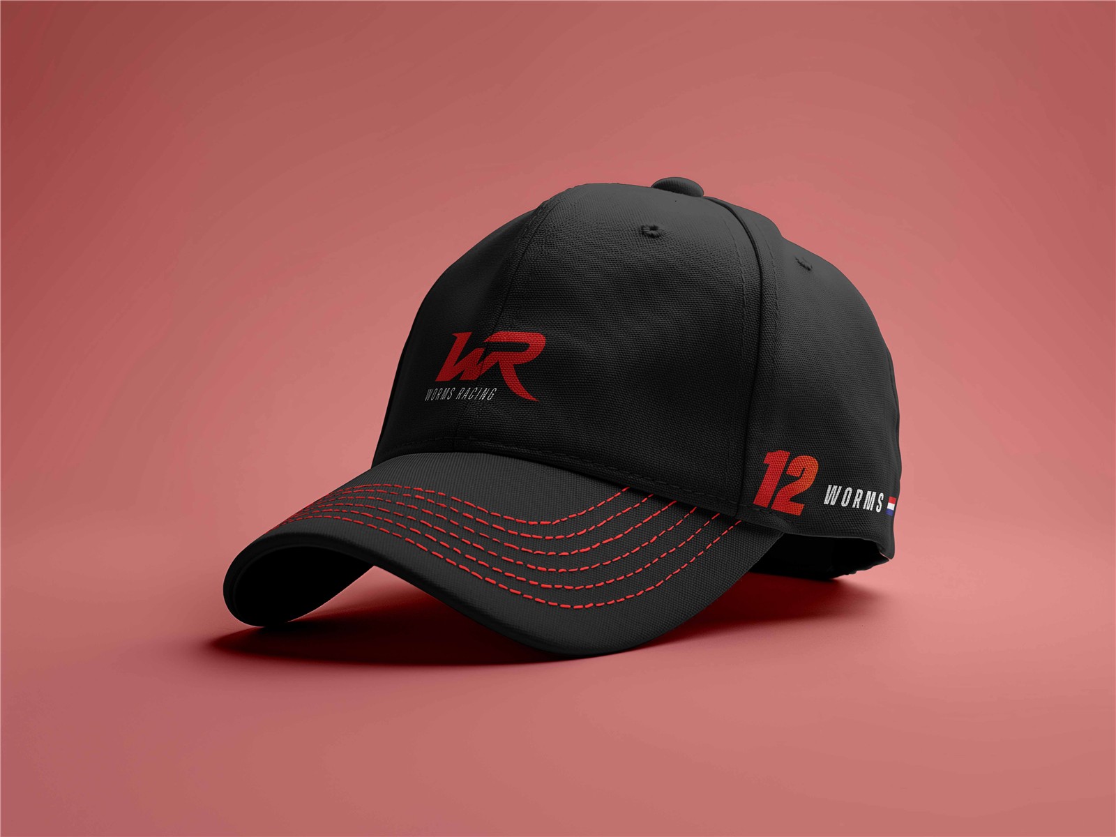 Zwarte pet met rood Worms Racing-logo op een rode achtergrond
